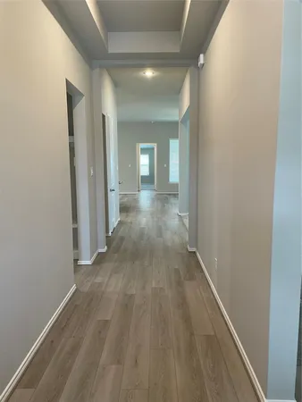 a view of a hallway with wooden floor