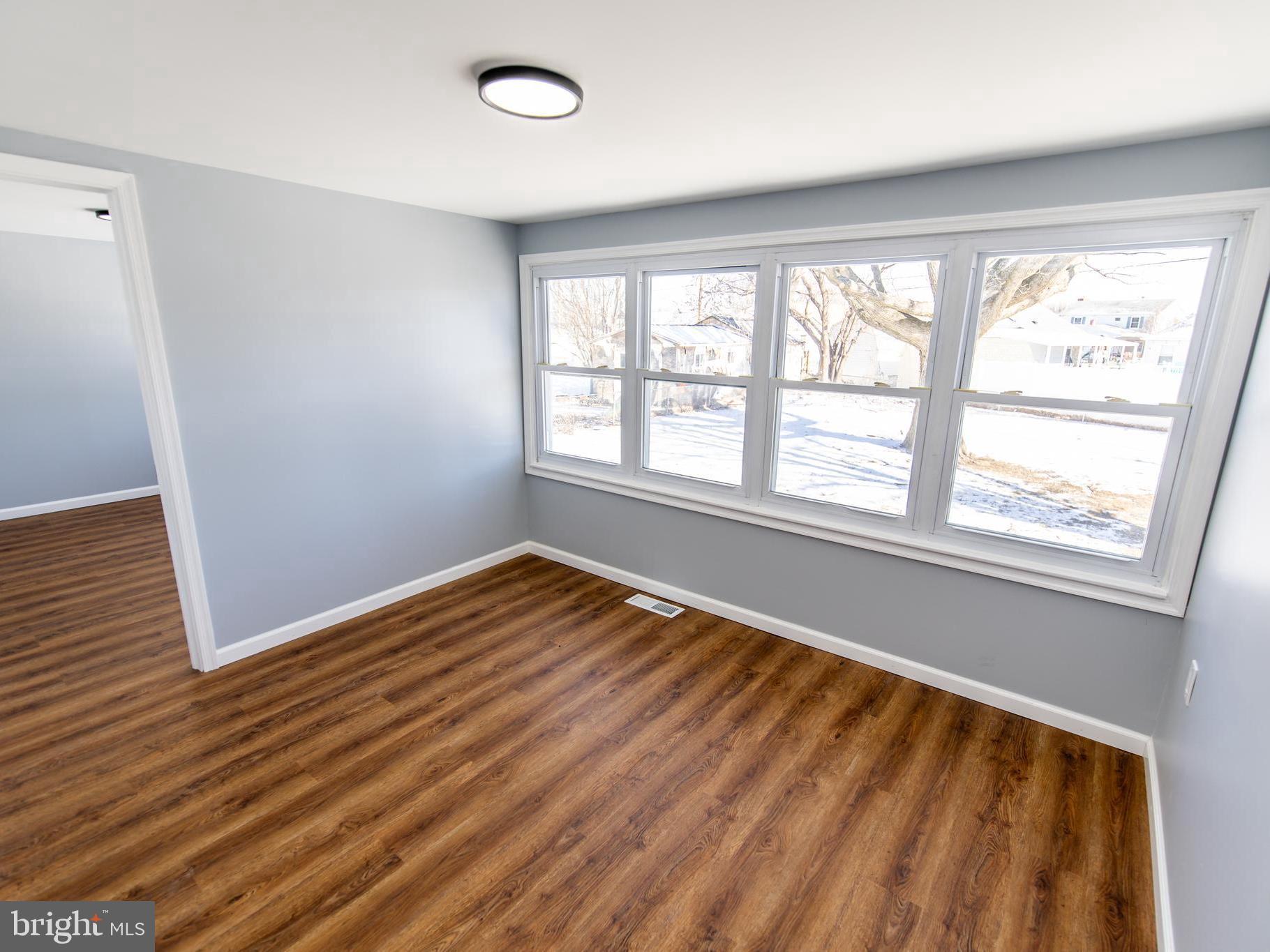 2605 Ambler Road Baltimore, MD 21222 - Photo 8 of 25 a view of an empty room with wooden floor and a window