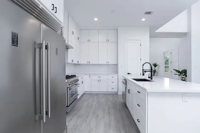a kitchen with white cabinets and stainless steel appliances