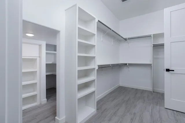 a view of walk in closet with empty racks