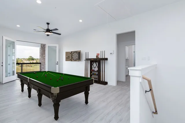 a room with pool table and windows