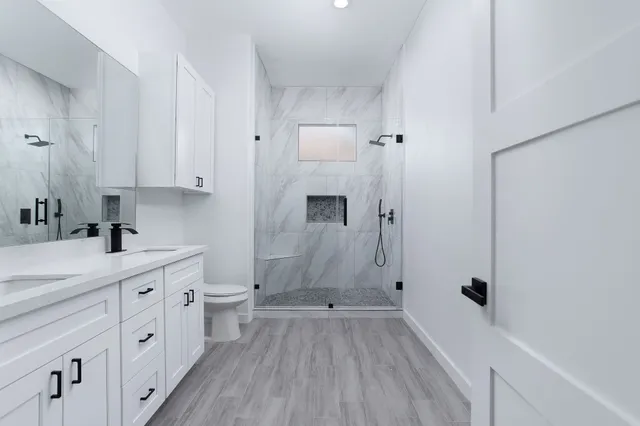 a bathroom with a sink a toilet and shower