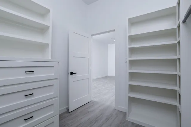 a view of walk in closet with empty racks
