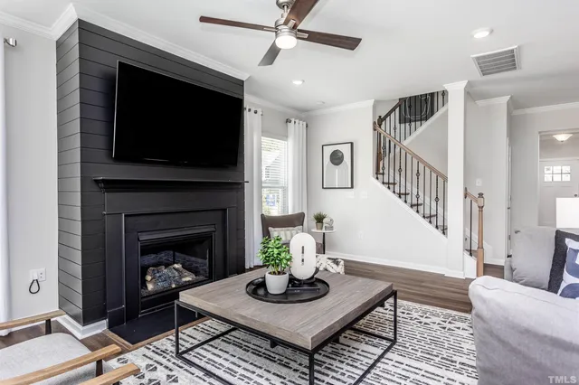 a living room with furniture a flat screen tv and a fireplace