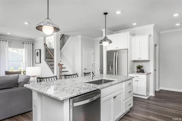 a kitchen with center island white cabinets and stainless steel appliances