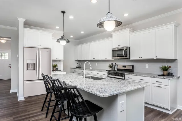 a kitchen with granite countertop a center island a sink stainless steel appliances and cabinets