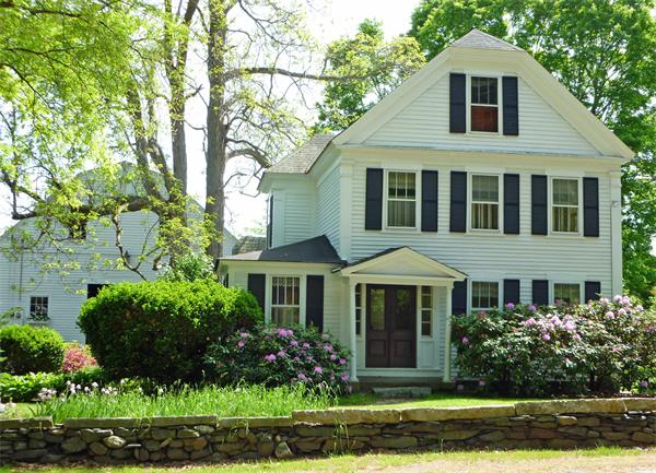 a front view of a house with a yard and potted plants
