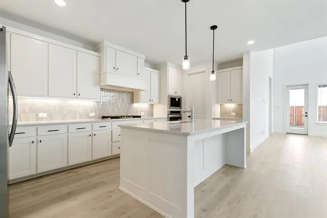 a kitchen with white cabinets appliances and a center island
