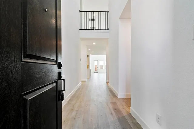 a view of a hallway with wooden floor and staircase