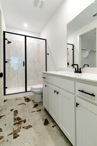 a bathroom with a sink mirror toilet and next to a large window
