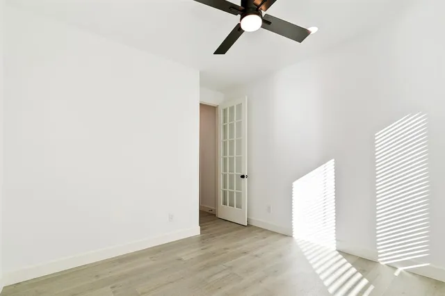 a view of a room with wooden floor and ceiling fan