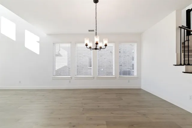 a view of a room with window chandelier chandeliers and wooden floor