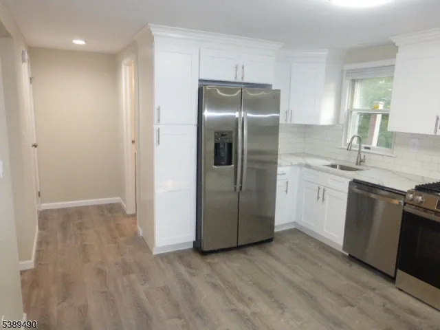 a kitchen with a refrigerator sink and cabinets