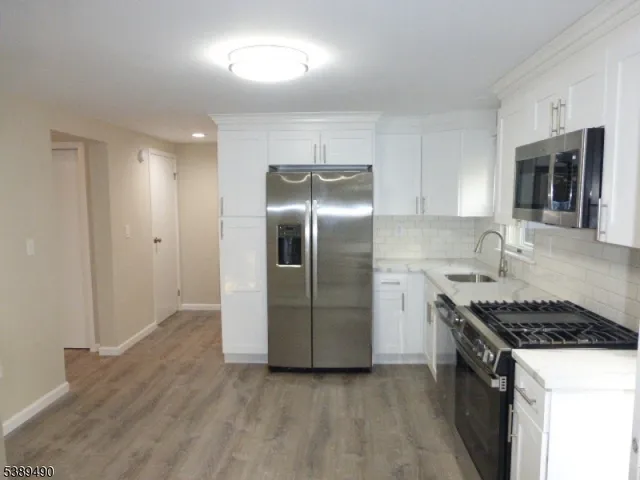 a kitchen with stainless steel appliances granite countertop a stove a refrigerator and a sink