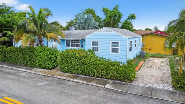 an aerial view of a houses with outdoor space and trees all around
