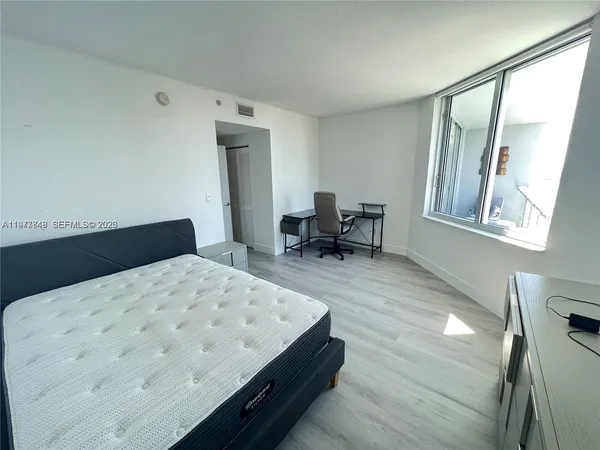 a living room with a bed furniture and a large window