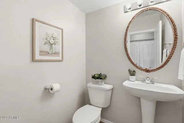 a bathroom with a toilet a sink and a mirror