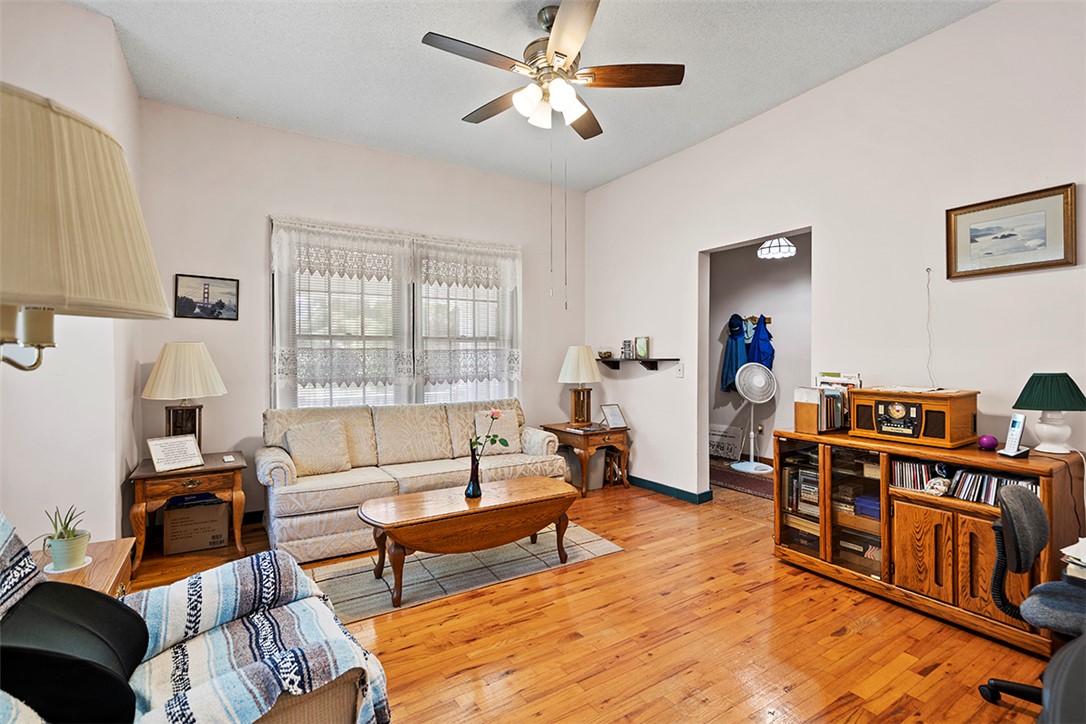 200 Louisiana Street Honea Path, SC 29654 - Photo 5 of 13 Natural wood flooring complements this inviting living area with a cooling ceiling fan.