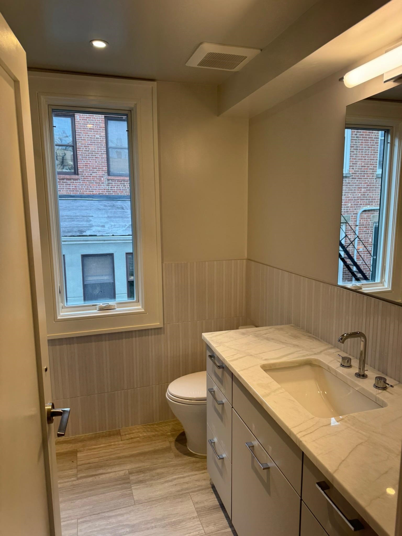 625 Court Street Hoboken, NJ 07030 - Photo 7 of 14 a bathroom with a granite countertop sink a toilet and mirror