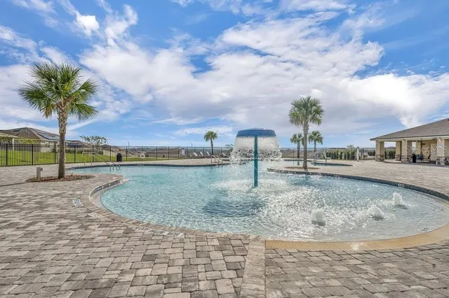 a view of a swimming pool with a lake view and houses in the back