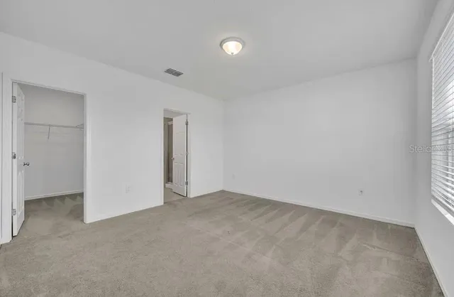 an empty room with an entryway and window