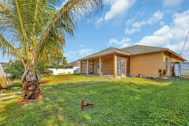 a backyard of a house with table and chairs