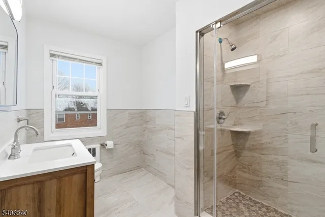 a bathroom with a sink mirror and shower