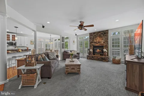 a living room with furniture a ceiling fan and a flat screen tv