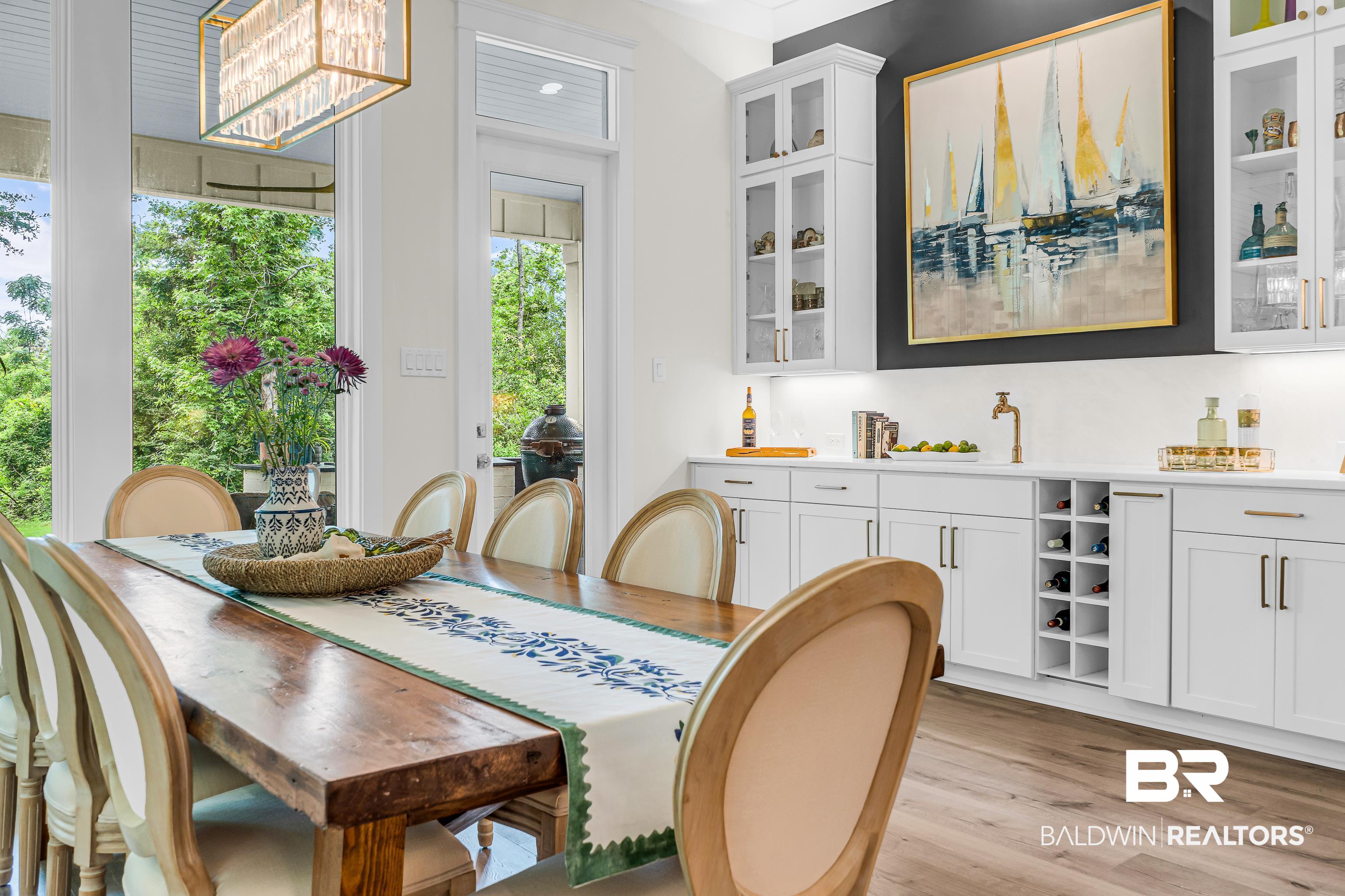 17541 Polo Ridge Boulevard Fairhope, AL 36532 - Photo 11 of 19 Dining area featuring wood-finish flooring, a rectangular wood dining table, and a linear chandelier