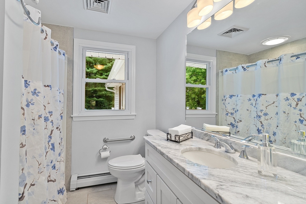 2 Johnson Road Chelmsford, MA 01824 - Photo 21 of 42 a bathroom with a granite countertop sink a toilet and a window