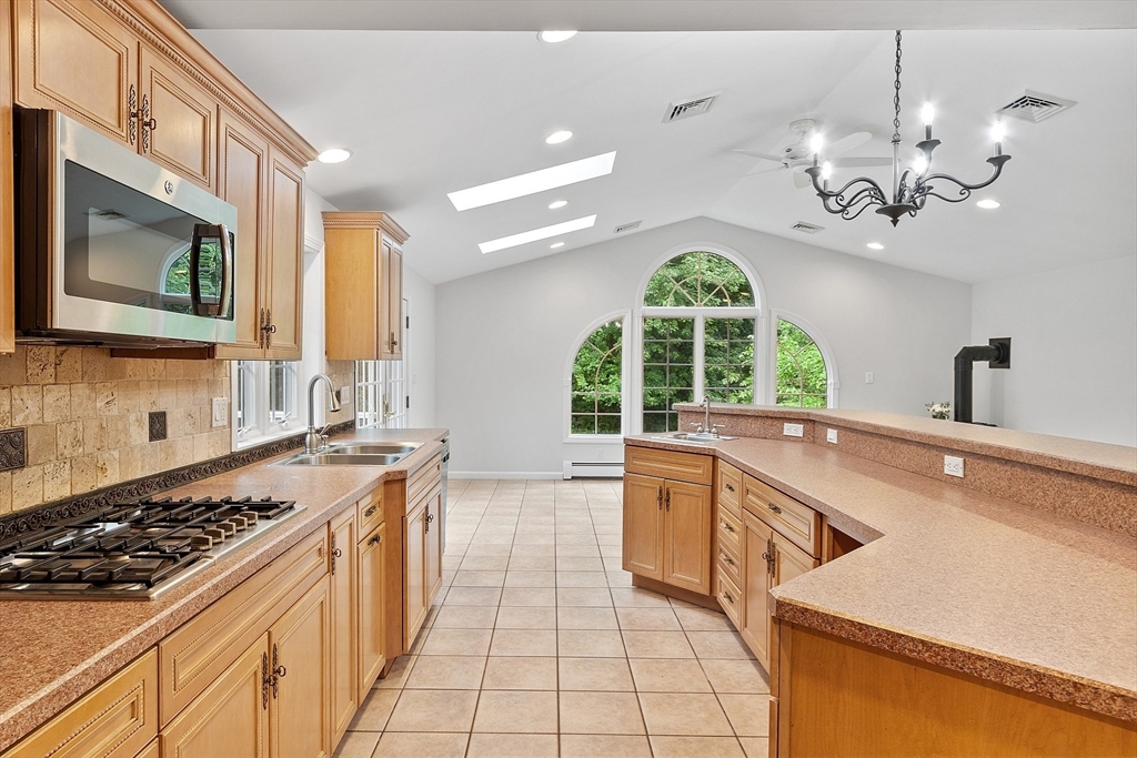 2 Johnson Road Chelmsford, MA 01824 - Photo 8 of 42 a kitchen with a stove a sink a microwave oven and a dining table