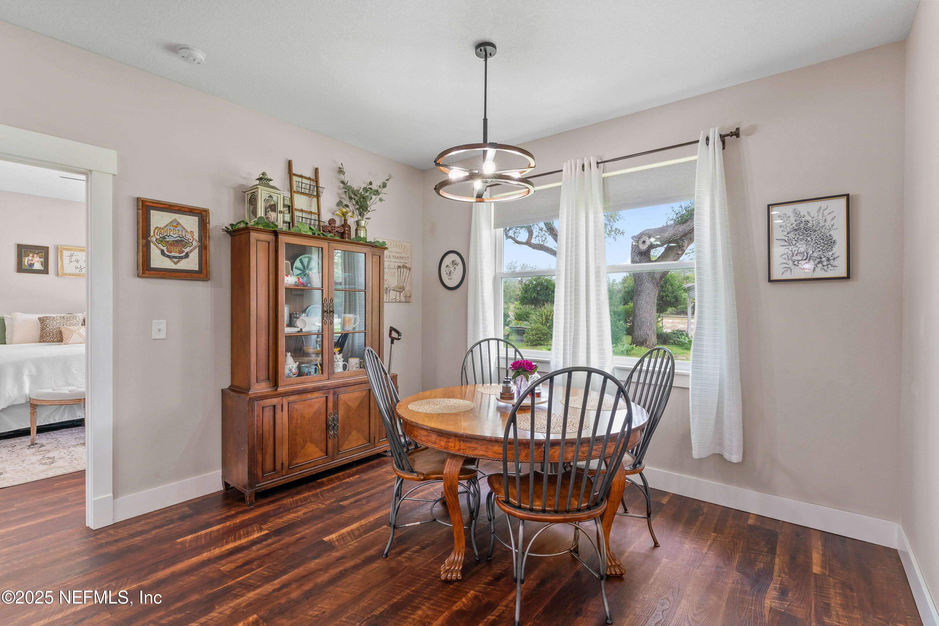 6228 Blue Marlin Drive Keystone Heights, FL 32656 - Photo 23 of 45 a dining room with wooden floor a chandelier a glass table and chairs