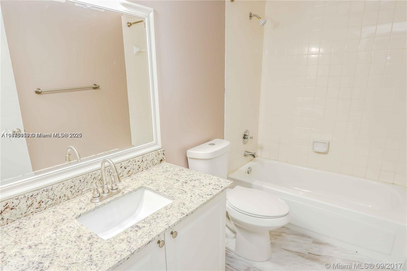 8734 Southwest 3rd Street, Unit 206 Pembroke Pines, FL 33025 - Photo 12 of 14 a bathroom with a granite countertop sink a toilet and bathtub
