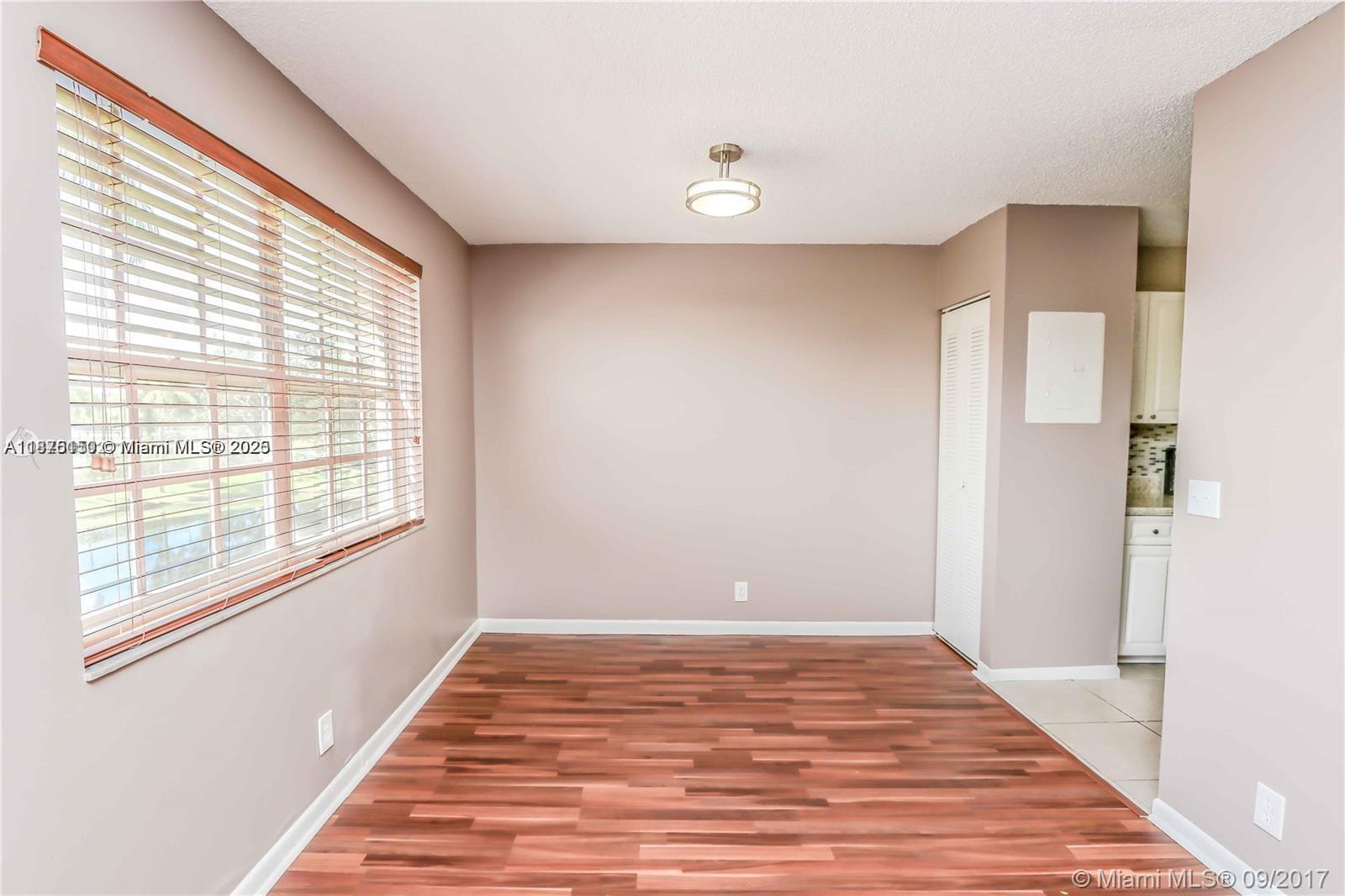 8734 Southwest 3rd Street, Unit 206 Pembroke Pines, FL 33025 - Photo 2 of 14 a view of an empty room with wooden floor and a window