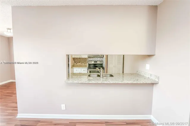 a kitchen with granite countertop white cabinets and white appliances