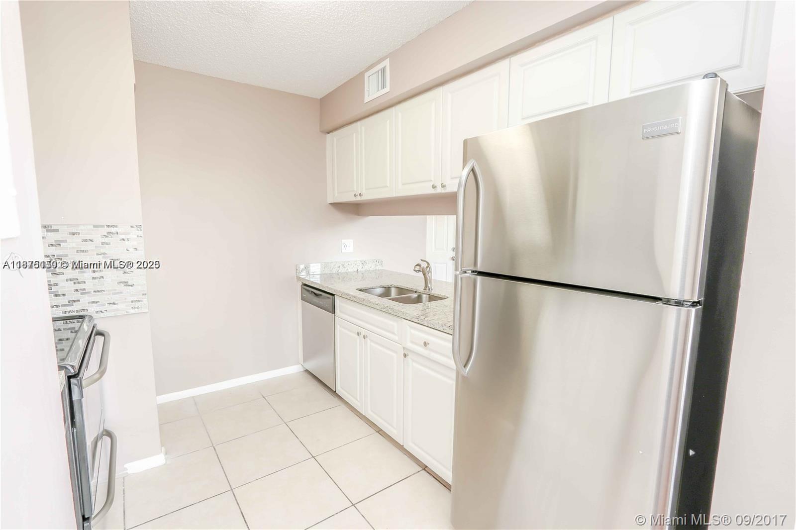 8734 Southwest 3rd Street, Unit 206 Pembroke Pines, FL 33025 - Photo 6 of 14 a kitchen with a refrigerator sink stove and cabinets