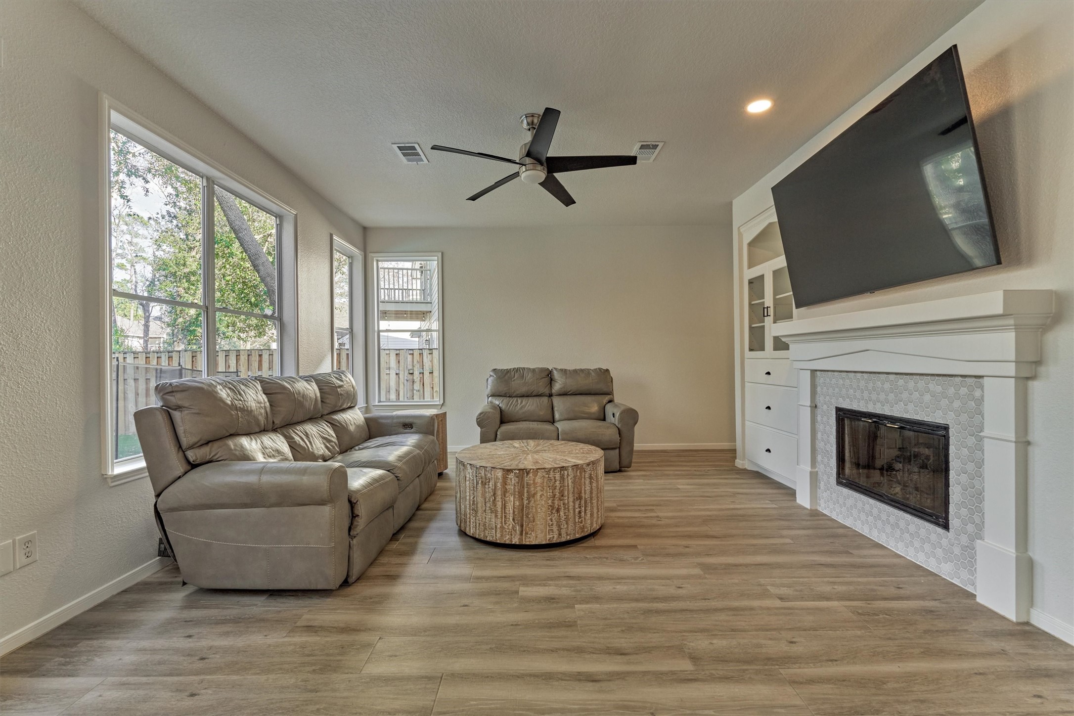 58 South Bethany Bend Circle Spring, TX 77382 - Photo 13 of 45 The den is flooded with natural light amidst a cozy fireplace!