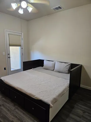 a view of an empty room with wooden floor fireplace and a window