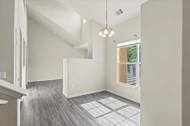a view of an empty room with window and fire place