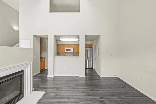 an empty room with wooden floor a ceiling fan and windows