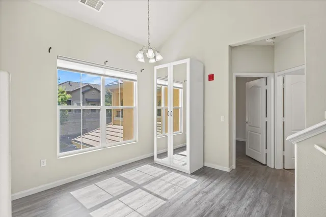 a view of a dining room with furniture a chandelier and wooden floor