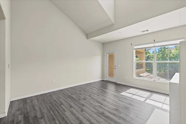a view of empty room with wooden floor