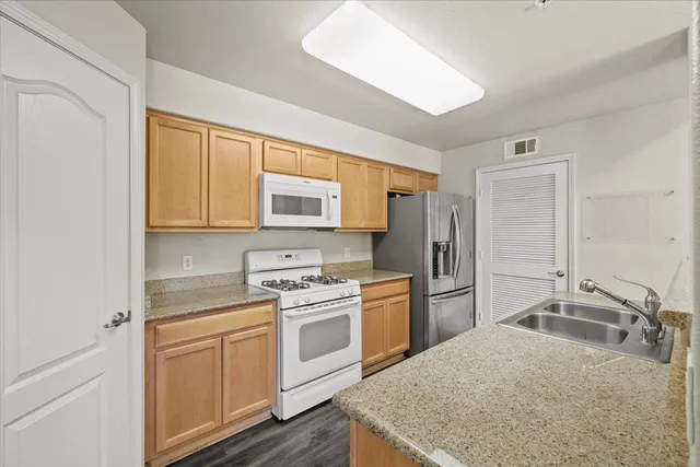 a kitchen with a sink stove and refrigerator