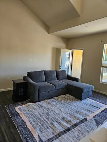 a view of a livingroom with wooden floor and a fireplace
