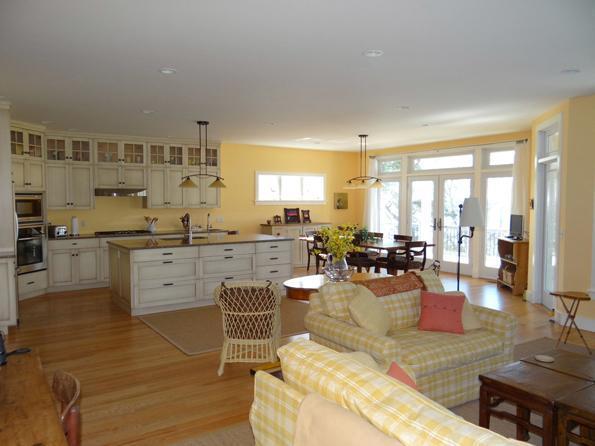 64 Gibson Road Orleans, MA 02653 - Photo 11 of 27 a living room with couches and kitchen view with wooden floor