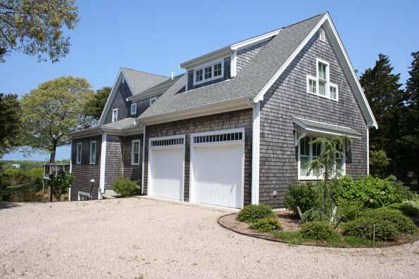 64 Gibson Road Orleans, MA 02653 - Photo 3 of 27 a front view of a house with a yard and garage