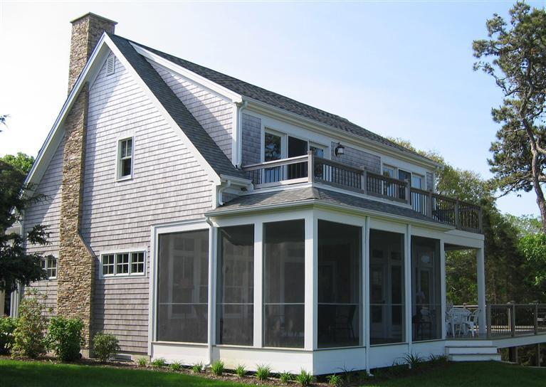 64 Gibson Road Orleans, MA 02653 - Photo 6 of 27 a view of a large white house with large windows and a small yard