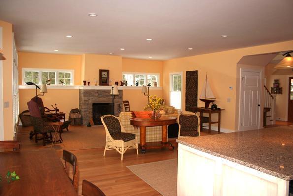 64 Gibson Road Orleans, MA 02653 - Photo 8 of 27 a living room with furniture a fireplace and a dining table with wooden floor