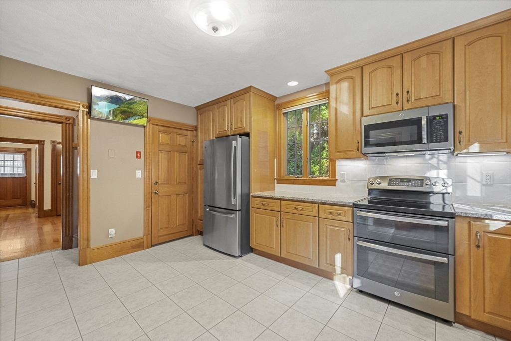 3 Laurel Street Woburn, MA 01801 - Photo 14 of 40 a kitchen with stainless steel appliances granite countertop a refrigerator and a stove top oven