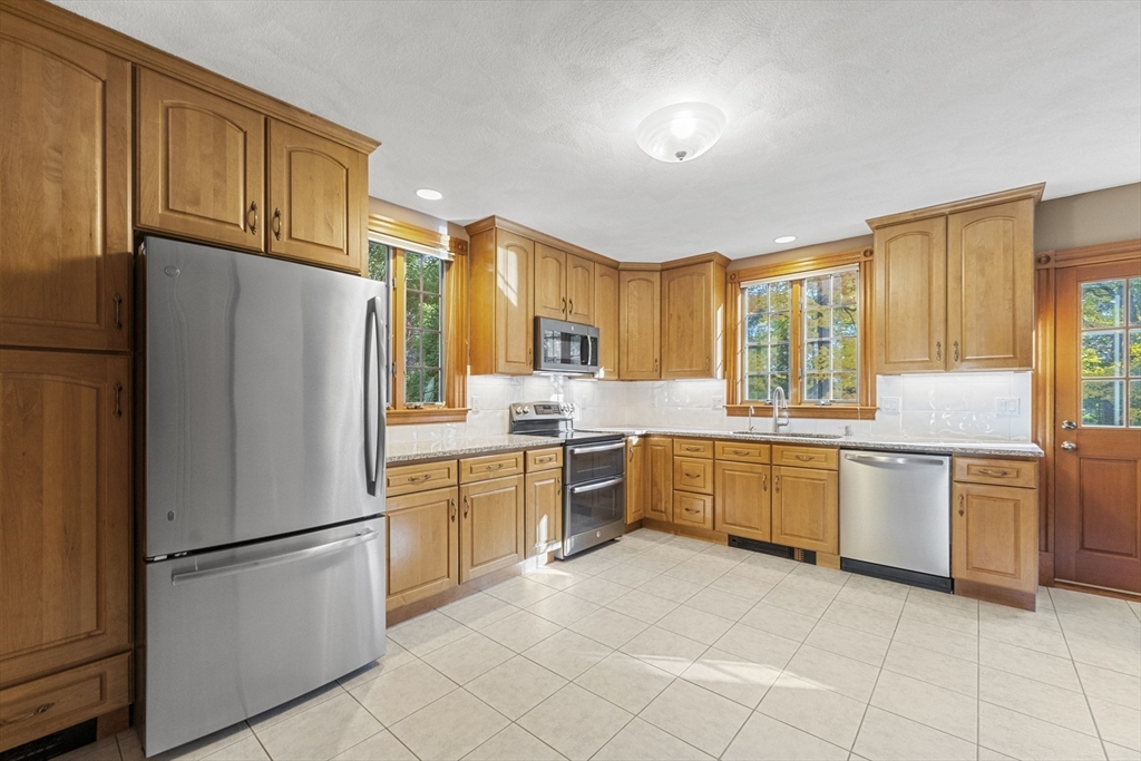 3 Laurel Street Woburn, MA 01801 - Photo 15 of 40 a kitchen with stainless steel appliances granite countertop a refrigerator sink stove microwave and cabinets